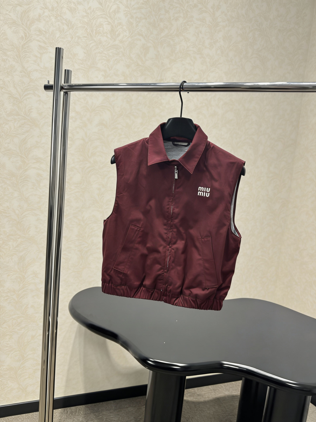NO:790859,MiuMiu 2026 spring and summer new burgundy vest, classic lapel + zipper design, simple retro style, technical fabrics are light and soft, comfortable and breathable to wear, the brand logo on the chest is very recognizable, the loose silhouette modifies the body, looks slim and fashionable, daily paired with short skirts, boots or contrasting color inner wear, easily get the American retro campus style, and the photo rate is super high!  Code numberSML,,miumiu,boots,skirts,19860909MiuMiu2026春夏新款酒红色马甲,经典翻领+拉链设计,简约复古风,科技面料轻薄柔软,穿着舒适透气,胸前品牌徽标超有辨识度,宽松廓形修饰身材,显瘦又时髦,日常搭配短裙、长靴或撞色内搭,轻松get美式复古校园风,拍照出片率超高！ 码数SML,,miumiu,boots,skirts,,Women's clothing