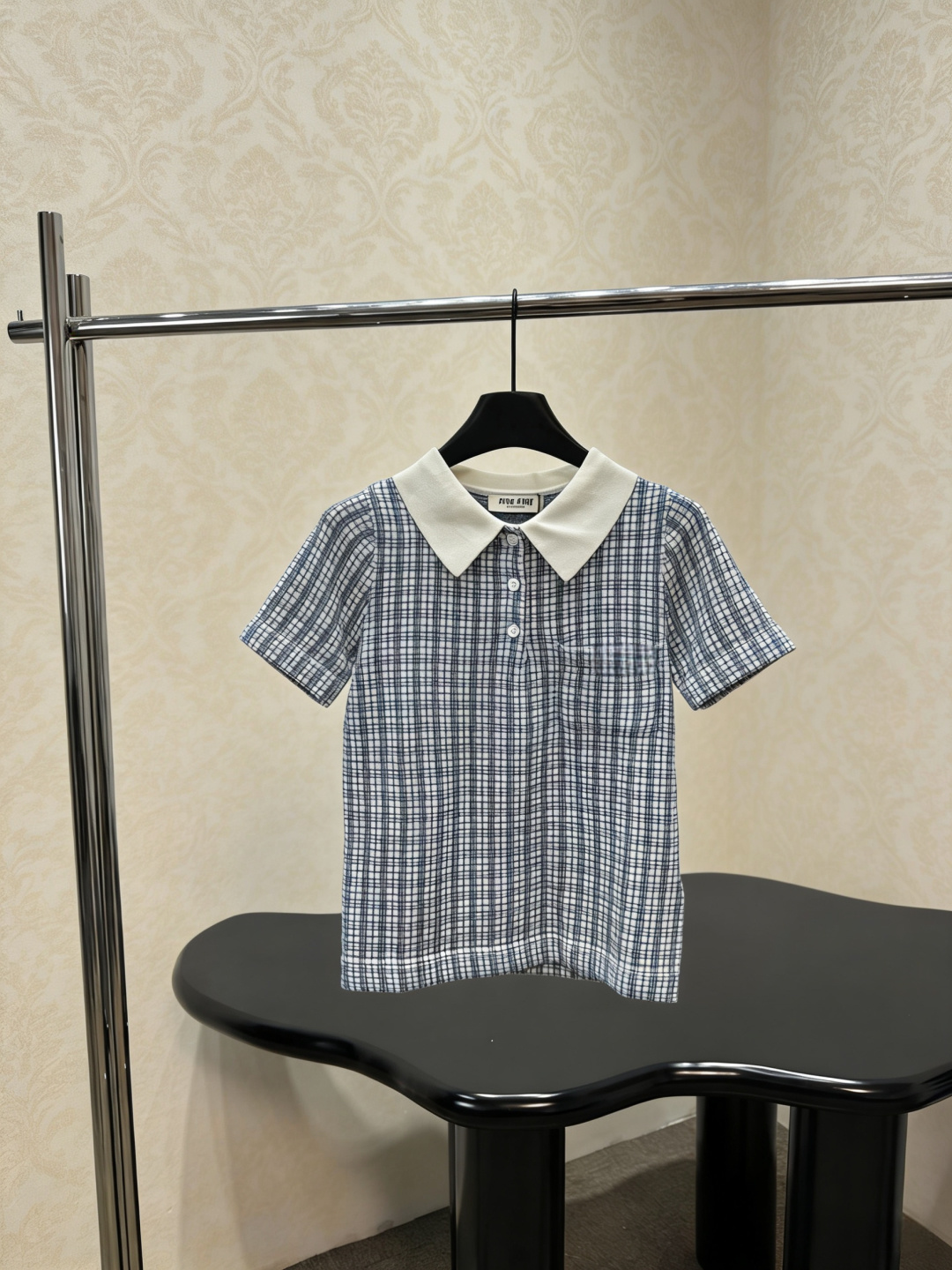 NO:793425,MiuMiu 2026 new spring and summer plaid knitted short-sleeved POLO shirt. This POLO shirt is designed with brown and white plaid, with dark brown lapels. It is retro and casual. The cotton fabric is breathable and comfortable. It is very suitable for summer. It has short sleeves + three buttons and small pockets on the chest. It is practical and detailed. It can be easily used for daily commuting and leisure occasions. It goes well with jeans or casual pants. A must-buy for simple style lovers!  Size SML,,miumiu,jeans,T-shirt,19860909MiuMiu2026春夏新款格纹针织短袖POLO衫,这款POLO衫采用棕白格纹设计,搭配深棕翻领,复古又休闲,棉质面料透气舒适,夏天穿超合适,短袖+三颗纽扣,胸前小口袋点缀,实用又有细节感,日常通勤、休闲场合都能轻松驾驭,搭配牛仔裤或休闲裤都很OK,简约风格爱好者必入！码数SML,,miumiu,jeans,T-shirt,,Women's clothing