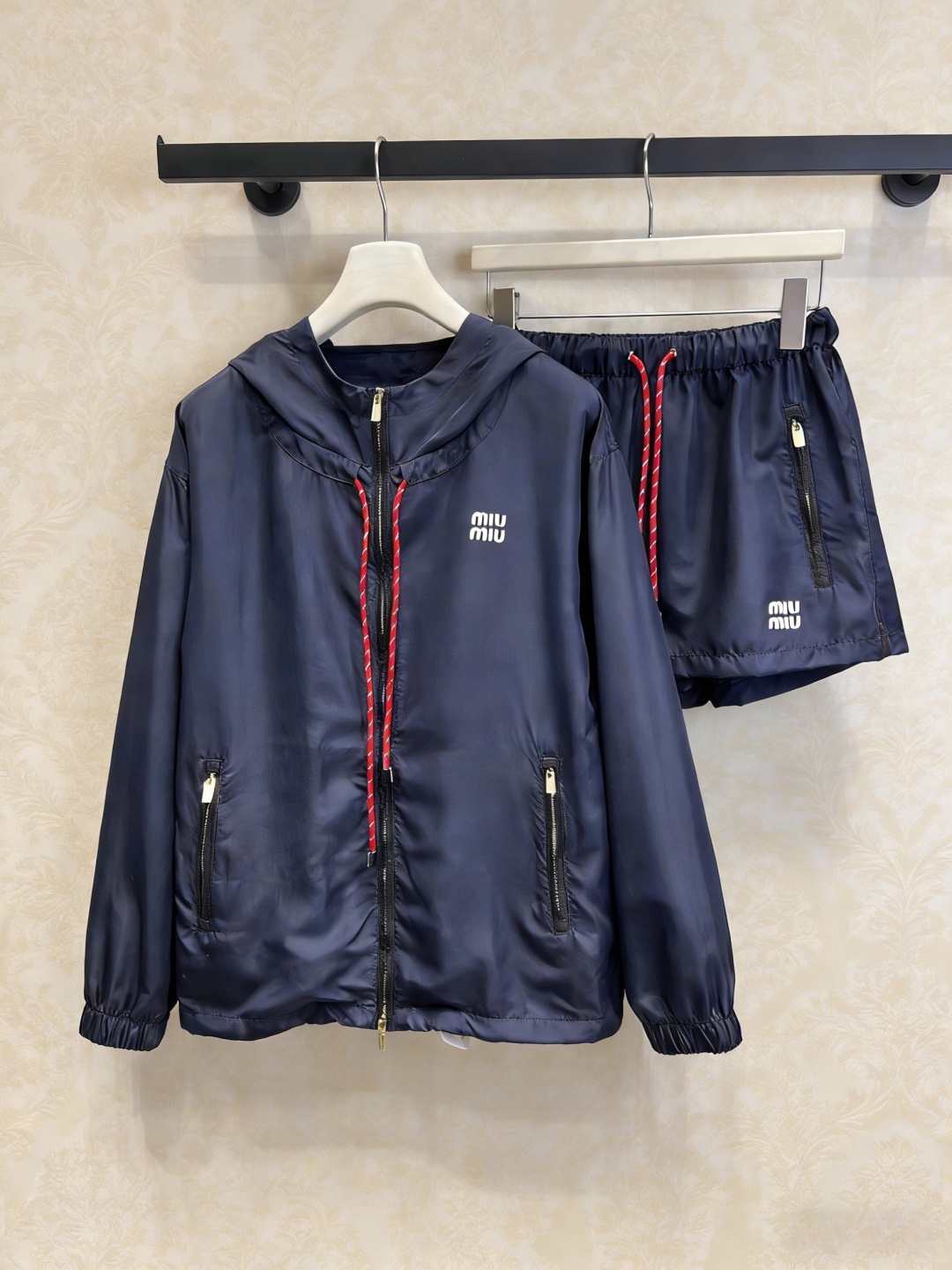 NO:795814,MiuMiu nylon drawstring sports suit, this dark blue nylon sports suit is made of light and thin materials and is very suitable for spring and summer. It has a hooded jacket + elastic waist shorts. The red and white contrasting drawstrings are very recognizable. The zipper fly + side pockets are practical and fashionable. The shorts also have drawstrings and zippers. The details are perfect. The workwear style is combined with a sense of sportiness. It can be easily controlled for daily leisure or outdoor use. It is comfortable and fashionable, and can easily create a casual look!  Size SML outside,,miumiu,shorts,jackets & coats,hats,19860909MiuMiu尼龙抽绳运动套装,这套深蓝尼龙运动套装,轻薄材质超适合春夏,连帽外套+松紧腰短裤,红白撞色抽绳超有辨识度,拉链门襟+侧边口袋实用又时髦,短裤同样有抽绳和拉链,细节满分,工装风融合运动感,日常休闲or户外都能轻松驾驭,舒适又时髦,轻松打造随性造型！码数SML 外,,miumiu,shorts,jackets & coats,hats,,Women's clothing