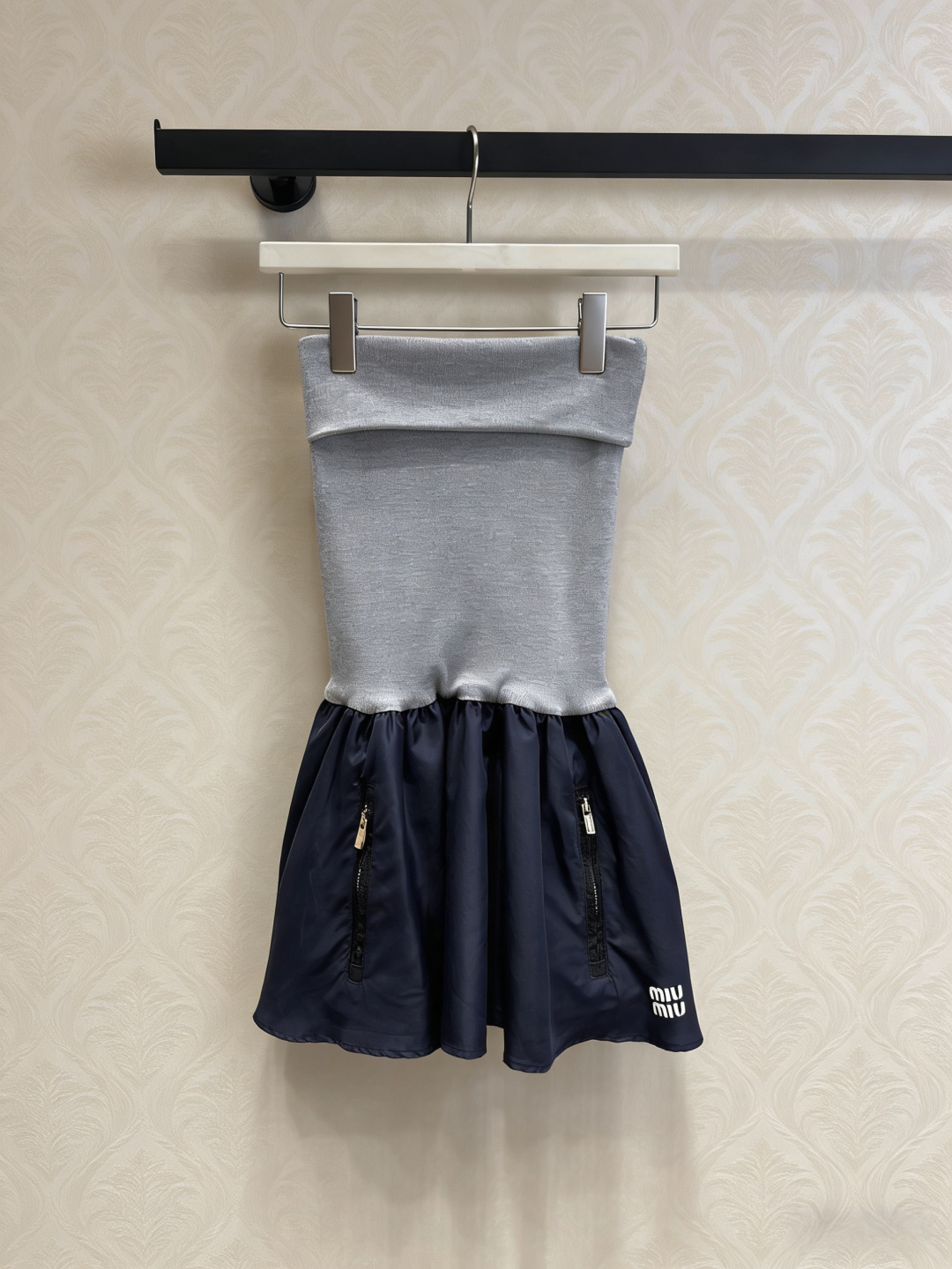 NO:795819,MiuMiu knitted tube top pleated skirt, this knitted tube top pleated skirt, gray knitted tube top + dark blue pleated skirt splicing, is simple and stylish. The zipper decoration on the skirt is very detailed, and the brand logo in the lower right corner is perfectly recognizable. The knitted fabric is close-fitting and comfortable, and the pleated skirt is light and flexible. It is very suitable for spring and summer. It can be easily worn in daily outings and parties. It goes well with high heels or sneakers, fashionable and practical!  Size SML,,miumiu,high heels,sneakers,skirts,19860909MiuMiu针织抹胸百褶裙,这款针织抹胸百褶裙,灰色针织抹胸+深蓝百褶裙拼接,简约又有设计感,裙摆拉链装饰超有细节,右下角品牌标志辨识度满分,针织面料贴身舒适,百褶裙轻盈灵动,春夏穿超合适,日常出街、聚会都能轻松驾驭,搭配高跟鞋或运动鞋都很出彩,时髦又实用！ 码数SML,,miumiu,high heels,sneakers,skirts,,Women's clothing