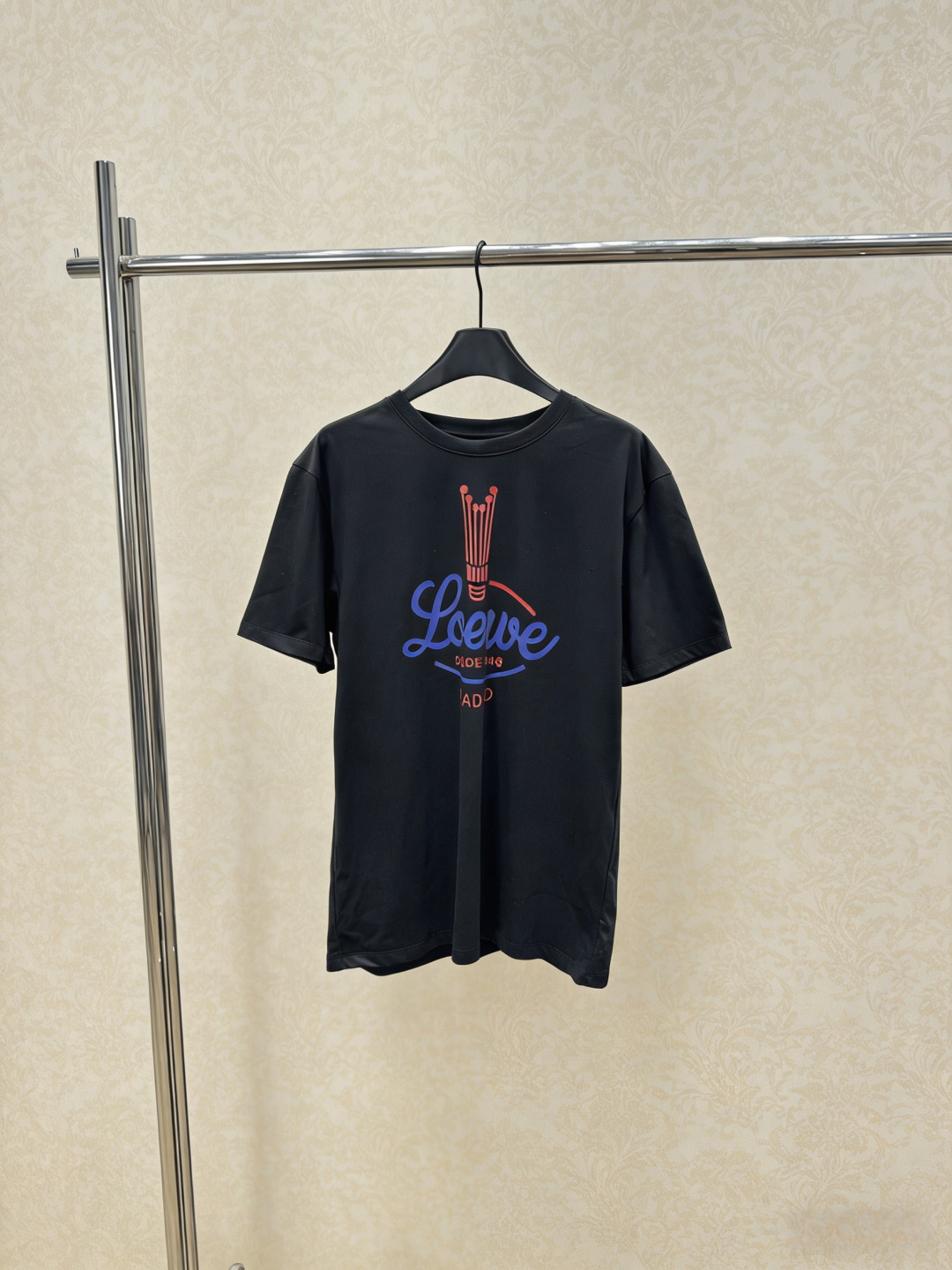 NO:798888,Loewe 2026 spring and summer show T-shirt, made of pleated cotton blended fabric, loose fit, same style for men and women. The logo on the chest is inspired by the 1940 archival crown pattern. The blue and red contrasting colors are super eye-catching. It can be easily switched between loose or waisted. It is very practical to wear two clothes in one!  The fabric is thick and not easy to stick to the body. It has a perfect sense of casualness and relaxation. It can be easily used for commuting and leisure. It is a must-have and versatile item in the wardrobe!  Code number SML,,loewe,tees,t-shirt,19860909Loewe 2026春夏秀款T恤,采用褶皱棉质混纺面料,宽松版型,男女同款,胸前Logo灵感来自1940年典藏王冠图案,蓝红撞色超吸睛,轻松切换宽松或收腰穿法,一衣两穿超实用！面料厚实不易贴身,随性松弛感满分,通勤休闲都能轻松驾驭,是衣橱必备百搭单品！码数SML,,loewe,tees，t-shirt,,Women's clothing
