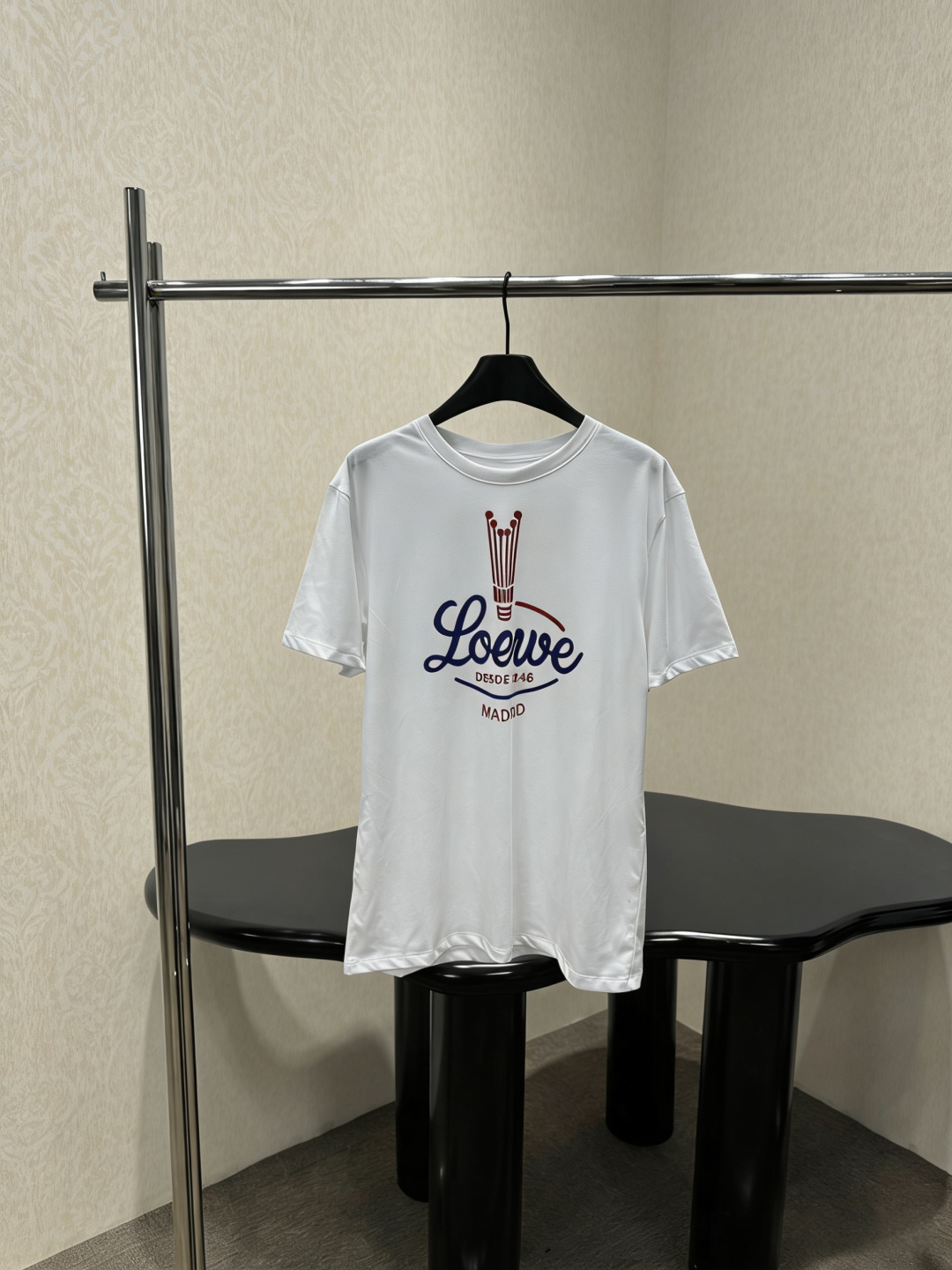 NO:798885,Loewe 2026 spring and summer show T-shirt, made of pleated cotton blended fabric, loose fit, same style for men and women. The logo on the chest is inspired by the 1940 archival crown pattern. The blue and red contrasting colors are super eye-catching. It can be easily switched between loose or waisted. It is very practical to wear two clothes in one!  The fabric is thick and not easy to stick to the body. It has a perfect sense of casualness and relaxation. It can be easily used for commuting and leisure. It is a must-have and versatile item in the wardrobe!  Code number SML,,loewe,tees,t-shirt,19860909Loewe 2026春夏秀款T恤,采用褶皱棉质混纺面料,宽松版型,男女同款,胸前Logo灵感来自1940年典藏王冠图案,蓝红撞色超吸睛,轻松切换宽松或收腰穿法,一衣两穿超实用！面料厚实不易贴身,随性松弛感满分,通勤休闲都能轻松驾驭,是衣橱必备百搭单品！码数SML,,loewe,tees，t-shirt,,Women's clothing