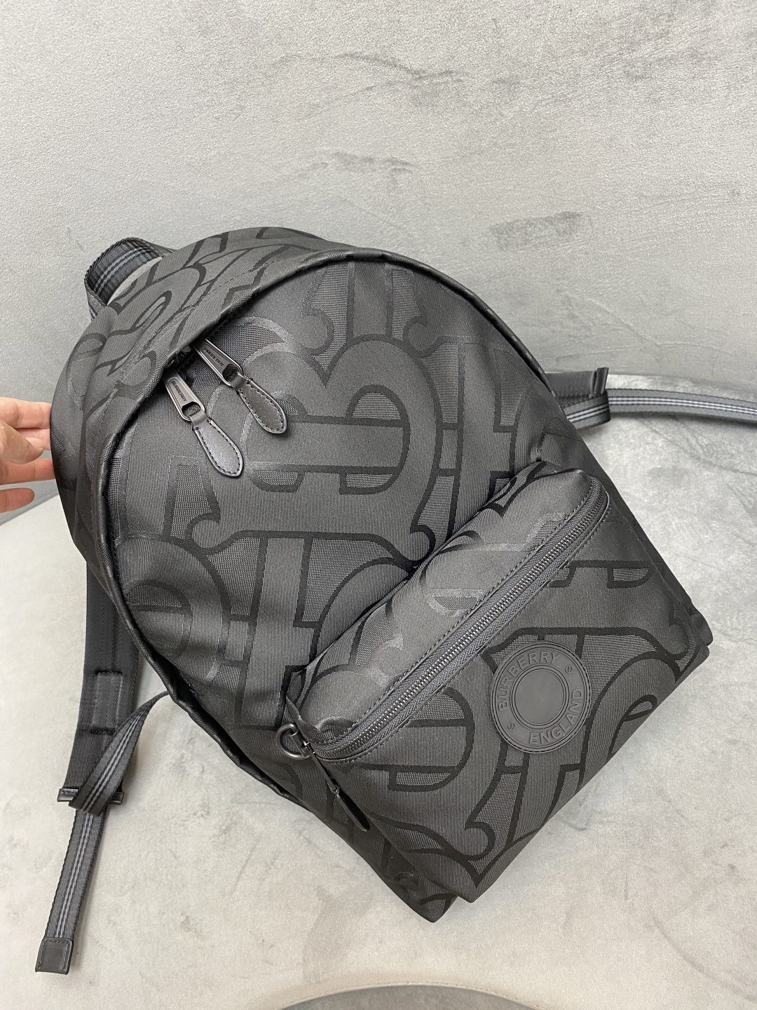 B brand backpack is made of recycled polyester fiber and cotton yarn, featuring Thomas Bur's exclusive embossed logo pattern, accented with signature striped mesh nylon details and brand emblem. Dimensions: 30.5 x 14.5 x 42.5cm 🌟 Model: 109560 image 1