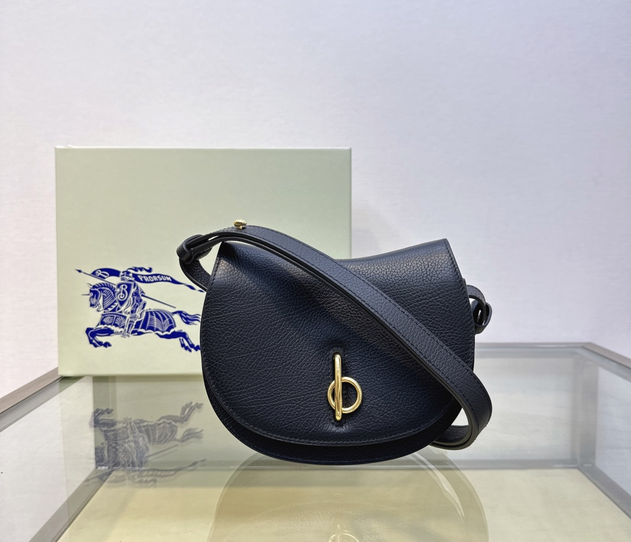 B’s latest stand-up bag is made of grained calfskin. Crafted in an Italian workshop, it features a checkered embossed leather lining. The curved silhouette is inspired by the rocking horses of childhood, and the flap closure features B-shaped hardware. With leather shoulder strap, it can be adjusted to switch between shoulder bag and cross-body bag styles.
Adjustable leather shoulder strap
Top flap with b-shaped closure
Hand painted painted edges
brushed metal accessories
Equestrian Knight logo (EKD) embossed on back side
Check-embossed lining
Size 19× 6× 16cm
Model 1661