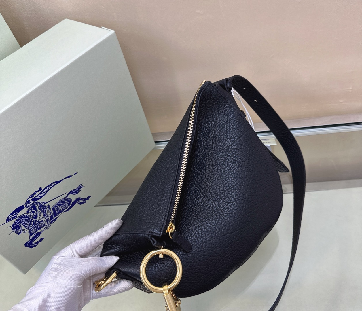 Burberry’s latest Cavalier War bag is made of grained calfskin fabric. Shoulder strap with