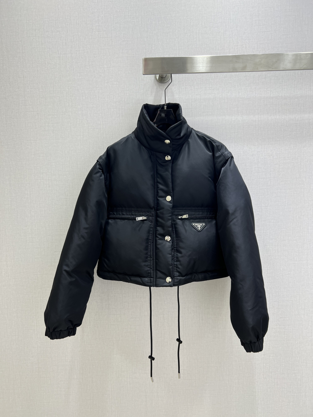 NO:687323,Highly recommended PRA*2025 new autumn and winter detachable two-wear short cotton jacket  Customized YB imported windproof and waterproof nylon material, its craftsmanship has been restored, and the material has been upgraded to improve the cold protection function in autumn and winter. The down cotton filling inside makes the whole piece light and warm. The neat stand-up collar design is matched with the iconic triangle logo, and the drawstring details make the short version more layered, cool and versatile, and directly full of fashion on the winter streets. The zippers on both sleeves can be detached to be worn as a jacket or a vest, ensuring a sense of fashion and switching outfits at will. One color SMLXL code  High quality ABC,,prada,jackets & coats,down jacket,19860909强烈推荐 PRA*2025秋冬新款 可拆卸两穿短款棉服外套 定制YB进口防风防水尼龙材质,其工艺还原,升级材质,提升秋冬御寒功能,羽绒棉填充内里,整件轻盈保暖.利落的立领设计搭配标志性三角标,抽绳细节让短款版型更具层次感,酷飒又百搭,冬日街头的时髦感直接拉满,两袖拉链可拆卸作外套或马甲两穿,确保时尚感,随意切换穿搭.一个色 SMLXL码 高品质ABC,,prada,jackets & coats,down jacket,,Women's clothing