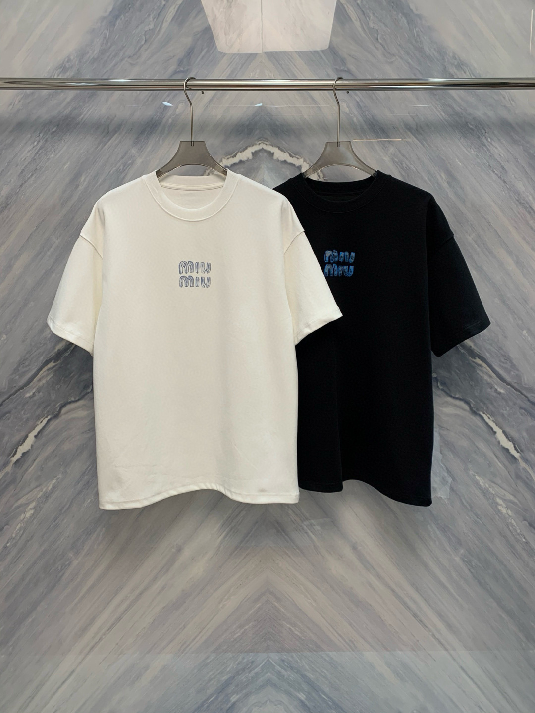 NO:148799,The 25-spring and summer new product original single-quality MIU home couple's same graffiti printed round neck high-grey heavy loose-fitting T-shirt, this MIU home graffiti printed high-grey heavy short-sleeved T-shirt is made of high-quality fabric, which is soft and comfortable to touch, and has an excellent wearing experience. The graffiti font design on the front is full of artistic and fashionable atmosphere, demonstrating personality and taste. The simple white background with blue graffiti letters is both classic and trendy. Whether it is daily outfits or casual parties, it can be easily controlled and shows a unique fashion attitude. The high-grey heavy fabric ensures the durability and texture of the clothes, and the details show the brand's ingenuity. The classic round neck design is simple and elegant, suitable for various occasions. The fine sewing process of the shoulders and cuffs enhances the overall sense of quality.  This T-shirt is not only a fashionable item, but also a versatile tool in your closet, allowing you to be confident at any time. Whether it is matched with jeans, casual pants or sweatpants, you can show different styles. Whether it is street style, casual pants or sports style, this T-shirt can perfectly fit and become the highlight of your daily outfits. Color: Black and White Size: S-XL S-Size bust 114, shoulder width 56, garment length 74, sleeve length 22 M bust 118, shoulder width 57, garment length 75, sleeve length 23 L bust 122, shoulder width 58, garment length 76, sleeve length 24 XL bust 126, shoulder width 59, garment length 77, sleeve length 25, miumiu, jeans, T-shirt,tees, t-shirt, alexander wang1986090925春夏新品原单品质MIU家情侣同款涂鸦印花圆领高克重宽松版型T恤,这款MIU 家涂鸦印花高克重短袖T恤,采用高品质面料,手感柔软舒适,穿着体验极佳.正面的涂鸦字体设计,充满艺术感和时尚气息,彰显个性与品味. 简洁的白色底色搭配蓝色涂鸦字母,既经典又不失潮流感.无论是日常穿搭还是休闲聚会,都能轻松驾驭,展现独特的时尚态度.高克重面料确保了衣物的耐用性和质感,细节之处尽显品牌匠心.经典的圆领设计,简约大方,适合各种场合.肩部和袖口的精细缝制工艺,提升了整体的品质感. 这款T恤不仅是一件时尚单品,更是你衣橱中的百搭利器,让你在任何时刻都能自信满满.无论是搭配牛仔裤、休闲裤还是运动裤,都能展现出不同的风格.无论是街头风、休闲风还是运动风,这款T恤都能完美契合,成为你日常穿搭的亮点. 颜色:黑色 白色 尺寸:S-XL S号胸围114,肩宽56,衣长74,袖长22  M号胸围118,肩宽57,衣长75,袖长23  L号胸围122,肩宽58,衣长76,袖长24  XL号胸围126,肩宽59,衣长77,袖长25,,miumiu,jeans,T-shirt,tees，t-shirt,alexander wang,Men's clothing