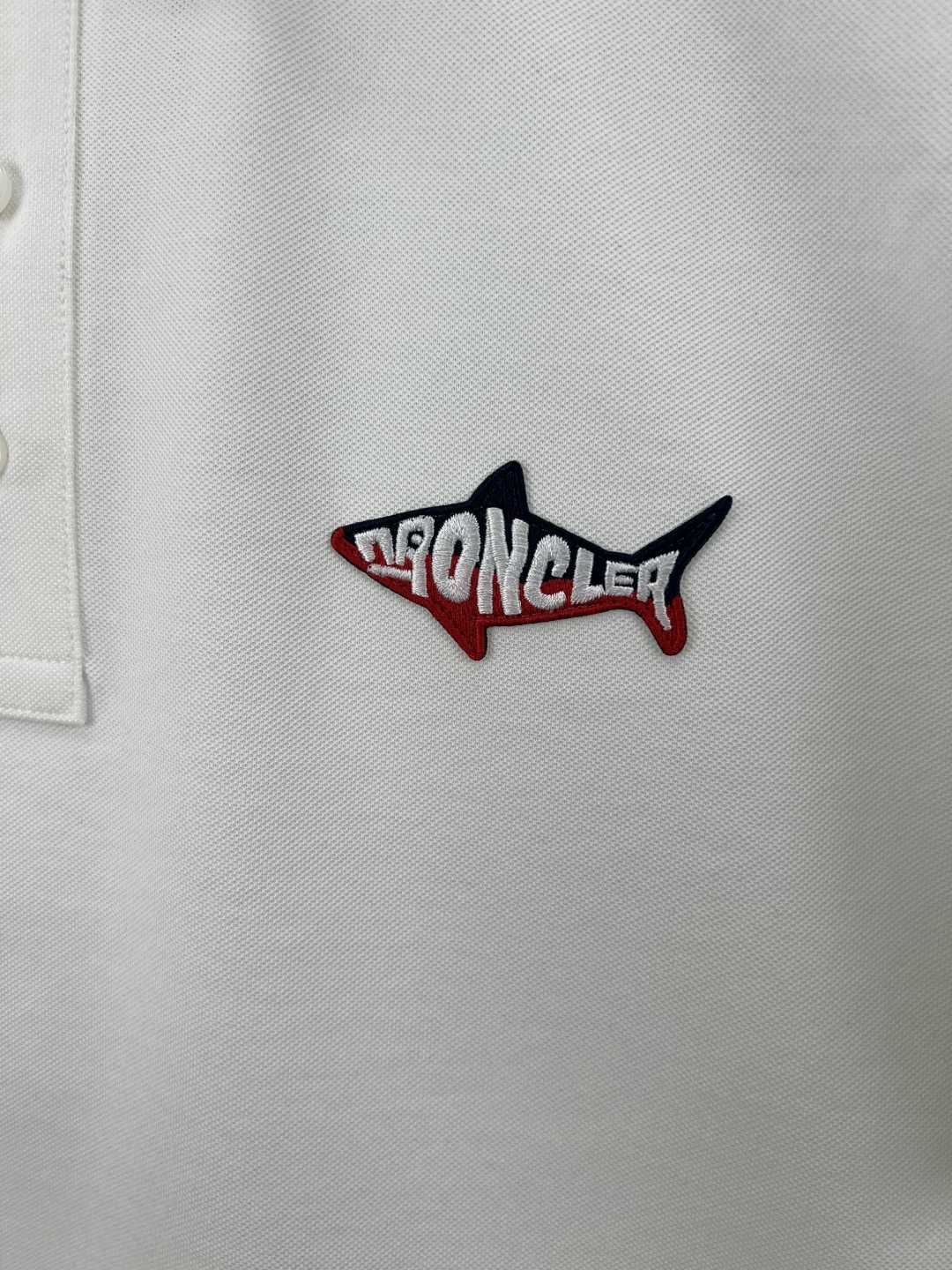 
Moncler 25春夏新品鲨鱼刺绣标识Polo衫，这款Polo设计灵感来源于海洋，点缀鲨鱼造型刺绣标