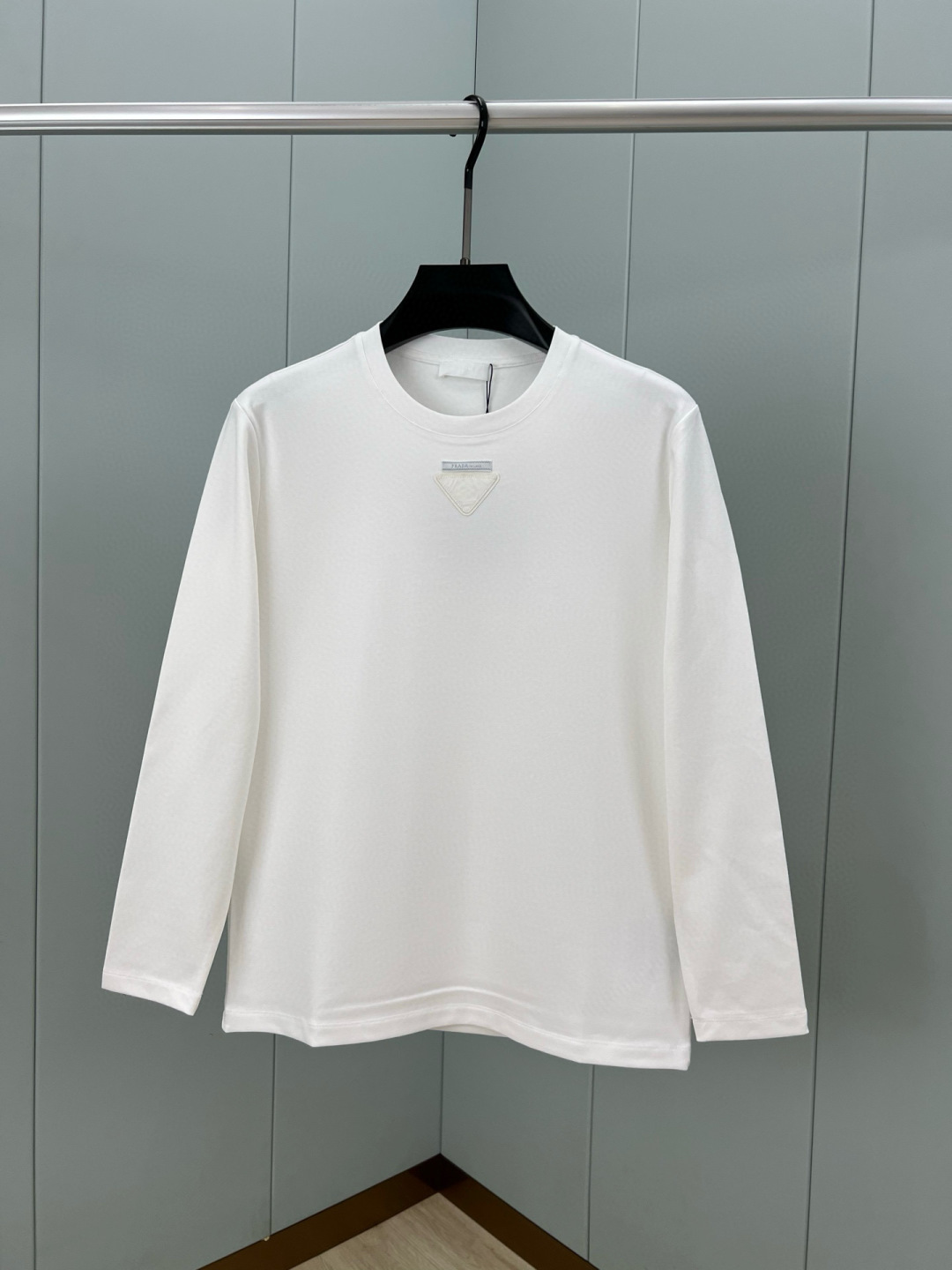  
Prada.普拉达 25秋冬新品三角形贴布徽标&缝制标签棉质长袖T恤衫，正面领口装饰有标志性的三角形