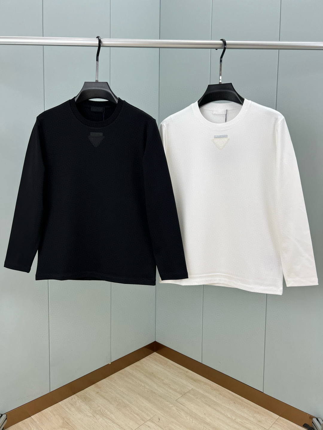  
Prada.普拉达 25秋冬新品三角形贴布徽标&缝制标签棉质长袖T恤衫，正面领口装饰有标志性的三角形