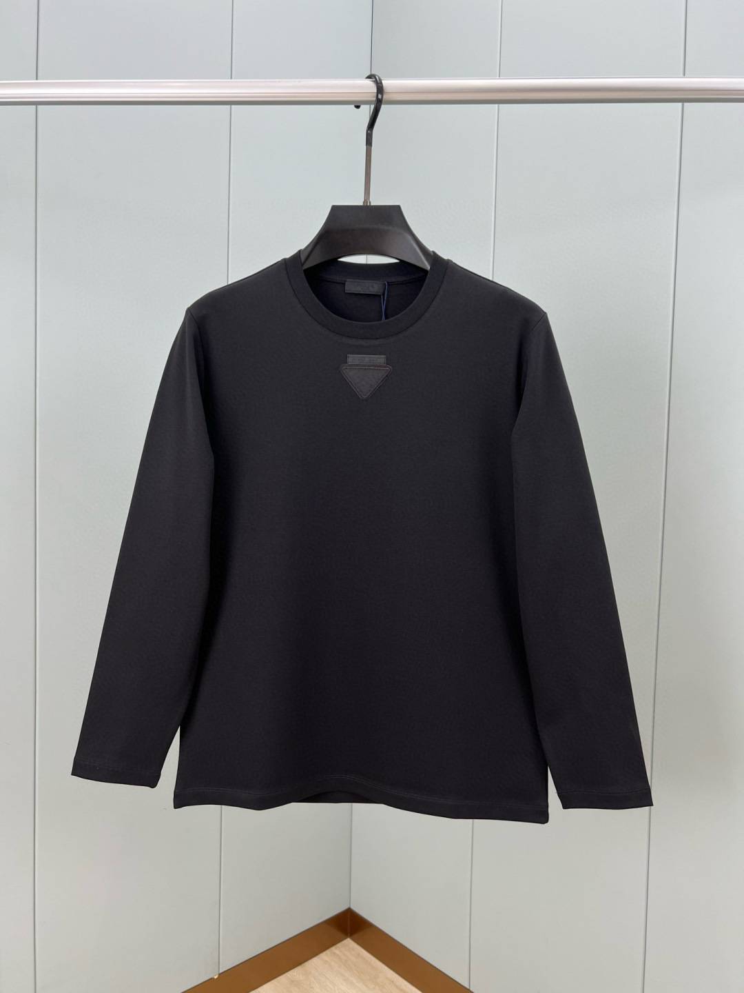  
Prada.普拉达 25秋冬新品三角形贴布徽标&缝制标签棉质长袖T恤衫，正面领口装饰有标志性的三角形