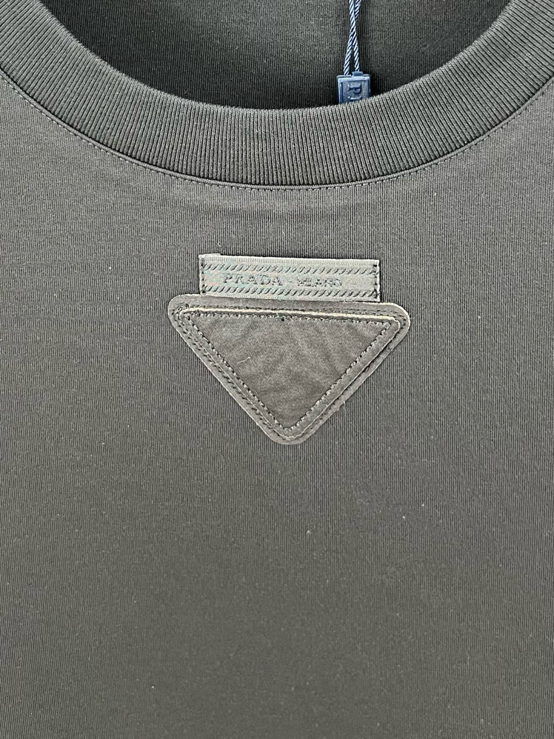  
Prada.普拉达 25秋冬新品三角形贴布徽标&缝制标签棉质长袖T恤衫，正面领口装饰有标志性的三角形