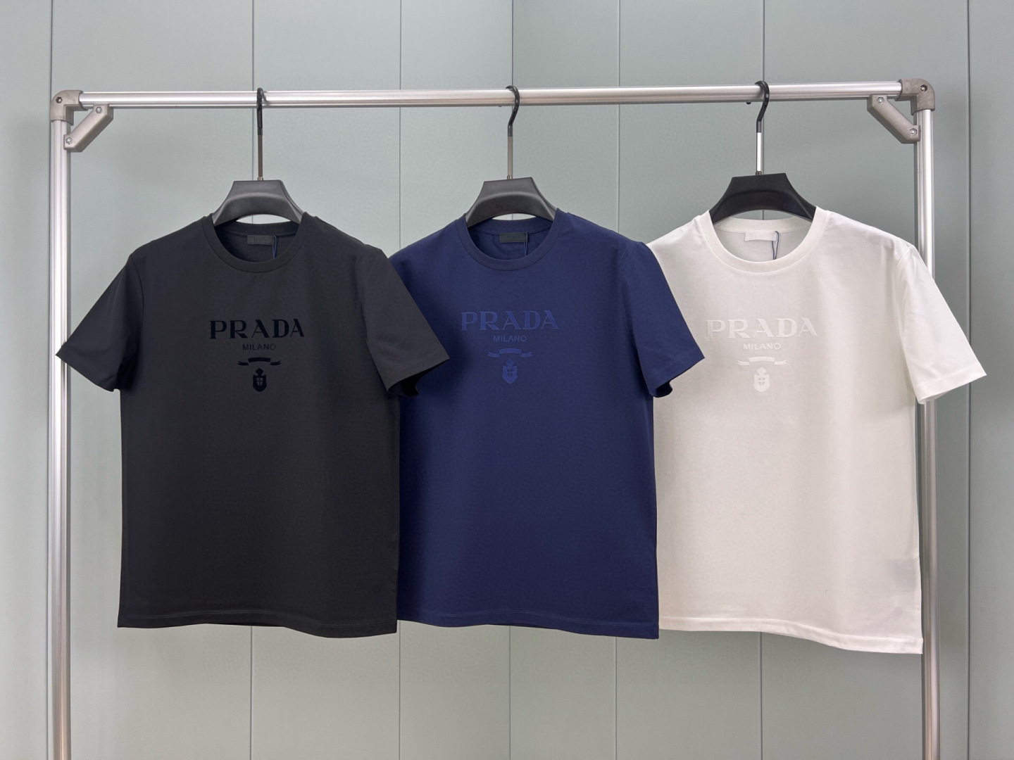 Prada.普拉达 25春夏新品品牌徽章同布色系植绒印花标识短袖T恤，定制80支双股丝光棉面料；黑色 白