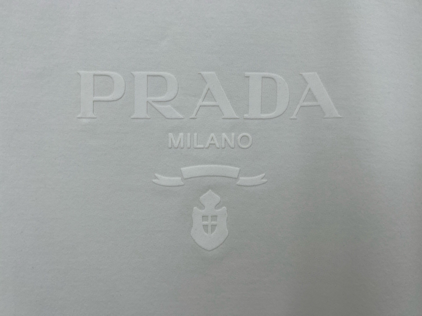 Prada.普拉达 25春夏新品品牌徽章同布色系植绒印花标识短袖T恤，定制80支双股丝光棉面料；黑色 白