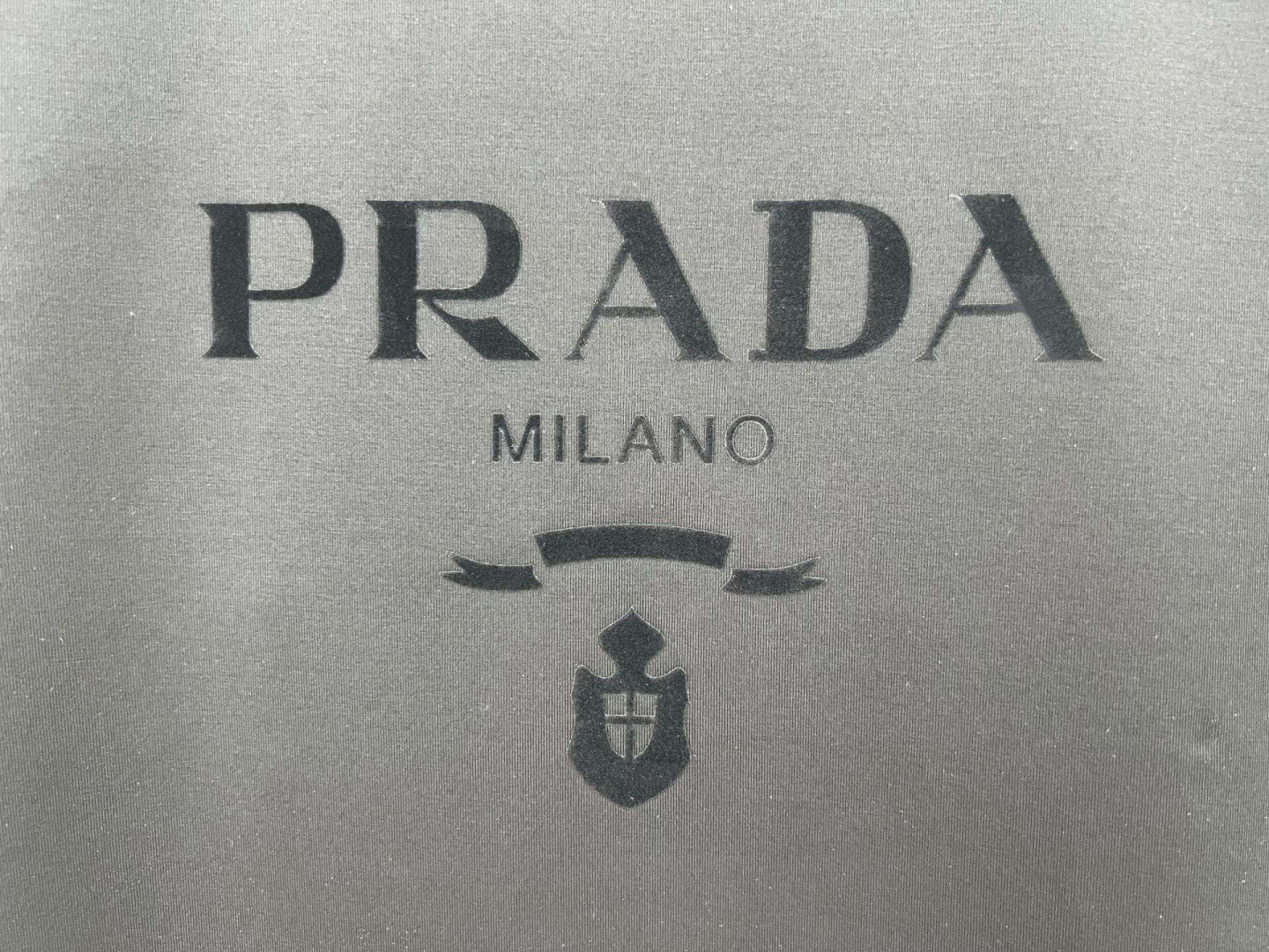 Prada.普拉达 25春夏新品品牌徽章同布色系植绒印花标识短袖T恤，定制80支双股丝光棉面料；黑色 白