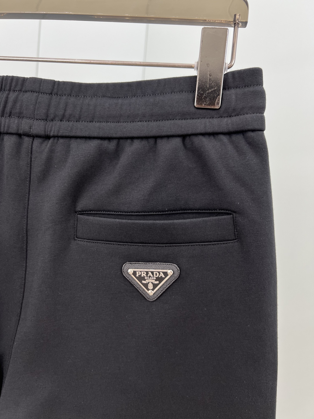 Prada.普拉达 25秋冬新品饰涂珐琅金属三角形徽标针织休闲长裤，正面两侧裤腿中位线条设计，背面袋口装