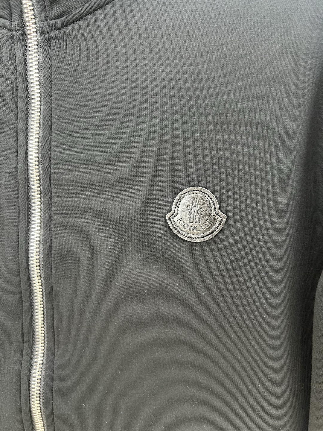 Moncler.蒙口 25秋冬新品饰皮革标识夹克外套，正面胸前皮革标识贴片点缀焕新品牌标识设计，立领拉链