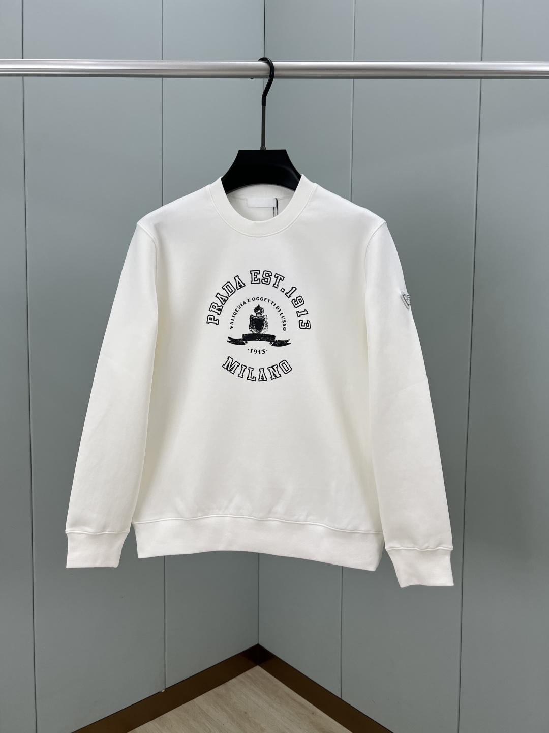 Prada.普拉达 25秋冬新品做旧印花标识针织圆领卫衣，左侧袖臂饰经典涂珐琅三角形金属徽标点缀，采用4