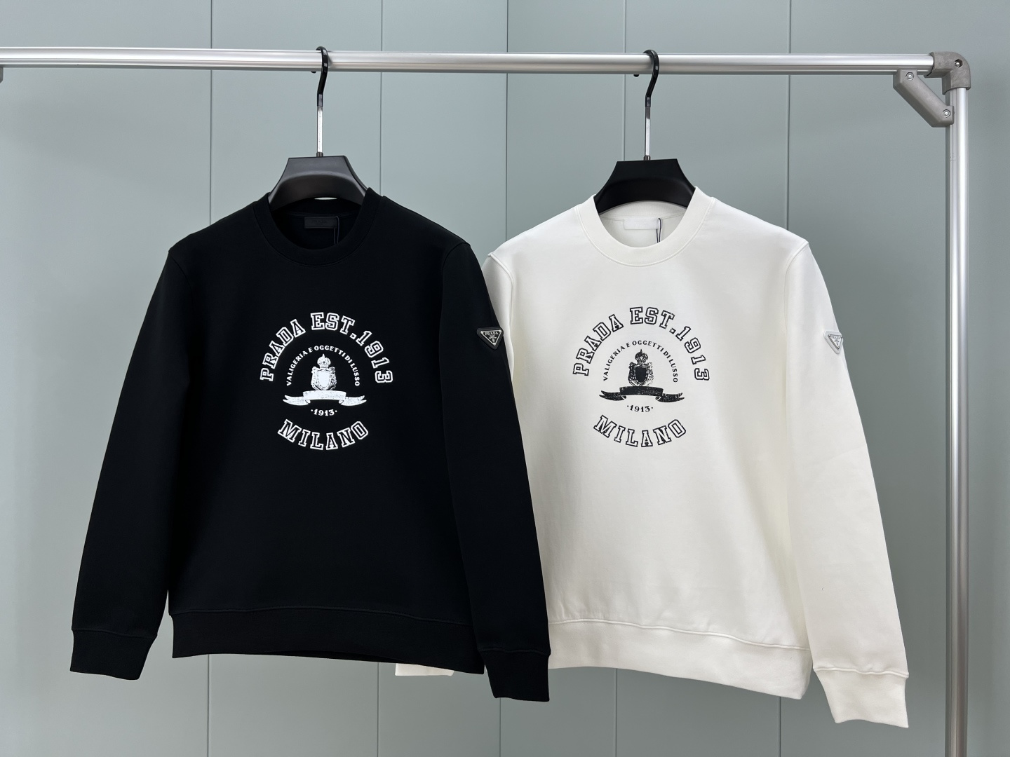 Prada.普拉达 25秋冬新品做旧印花标识针织圆领卫衣，左侧袖臂饰经典涂珐琅三角形金属徽标点缀，采用4