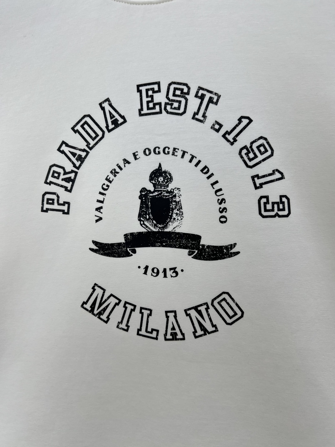 Prada.普拉达 25秋冬新品做旧印花标识针织圆领卫衣，左侧袖臂饰经典涂珐琅三角形金属徽标点缀，采用4