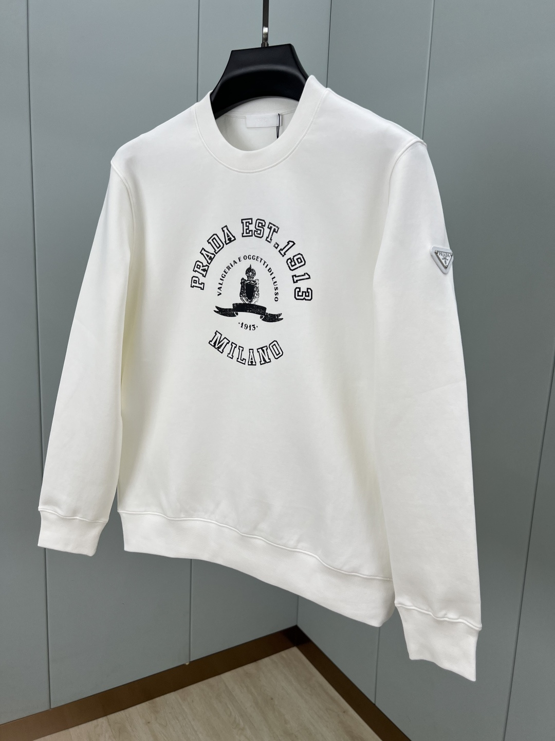 Prada.普拉达 25秋冬新品做旧印花标识针织圆领卫衣，左侧袖臂饰经典涂珐琅三角形金属徽标点缀，采用4