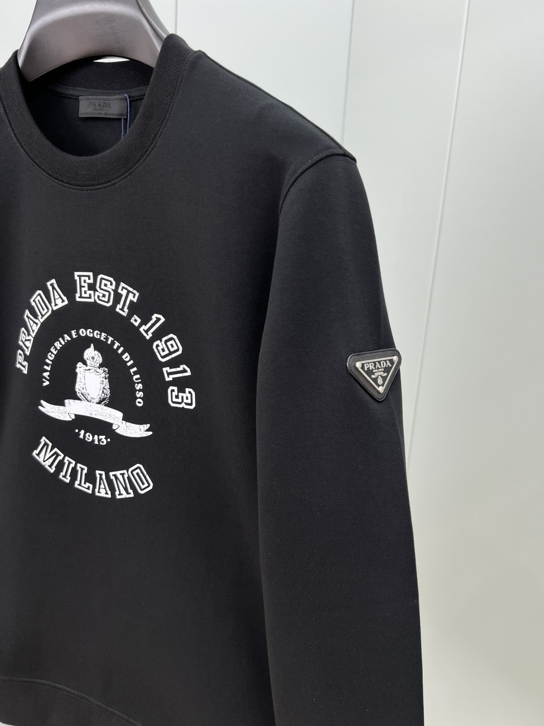 Prada.普拉达 25秋冬新品做旧印花标识针织圆领卫衣，左侧袖臂饰经典涂珐琅三角形金属徽标点缀，采用4