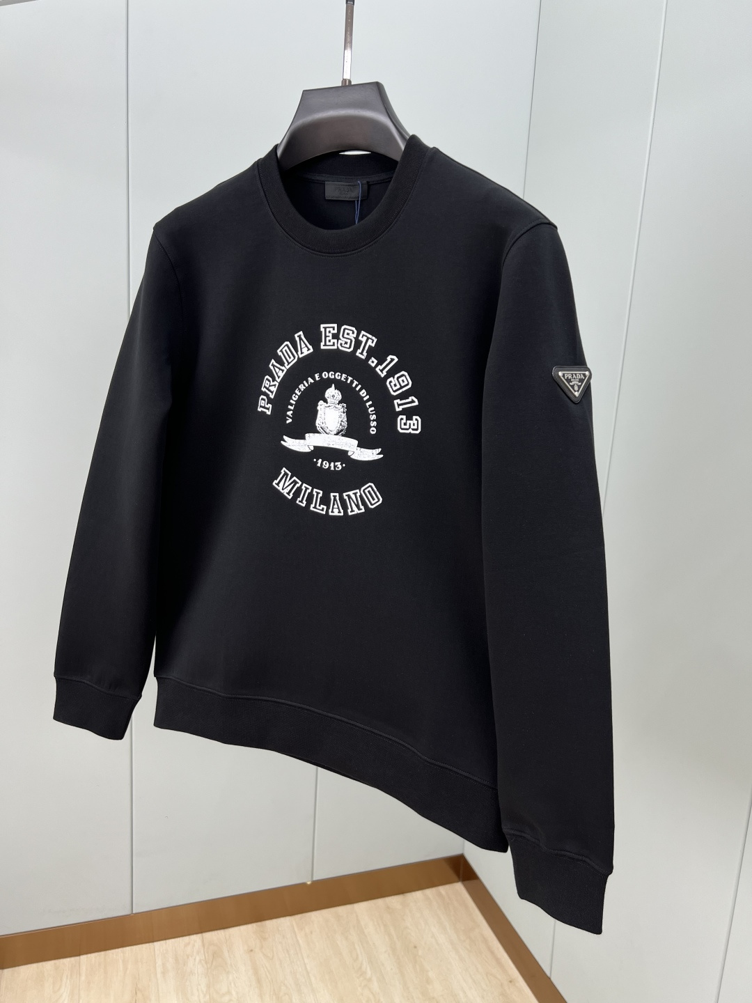 Prada.普拉达 25秋冬新品做旧印花标识针织圆领卫衣，左侧袖臂饰经典涂珐琅三角形金属徽标点缀，采用4