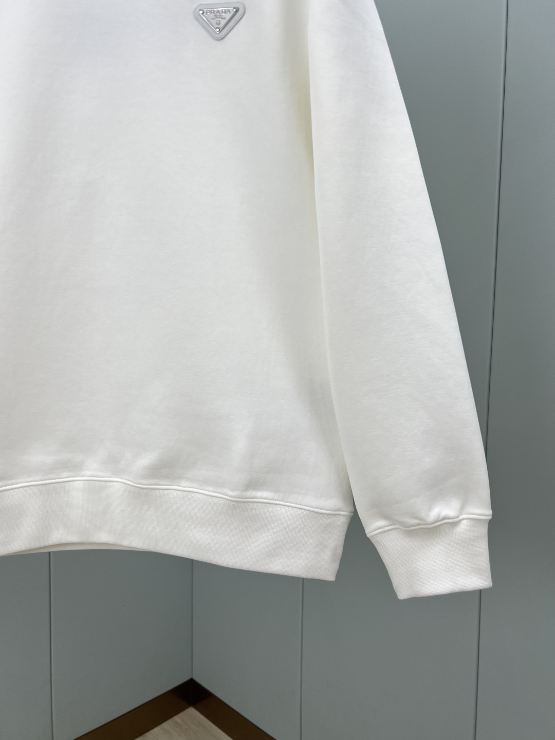 Prada.普拉达 25秋冬新品经典涂珐琅三角形金属徽标针织圆领卫衣，正面胸前饰有经典标志性特色三角标点