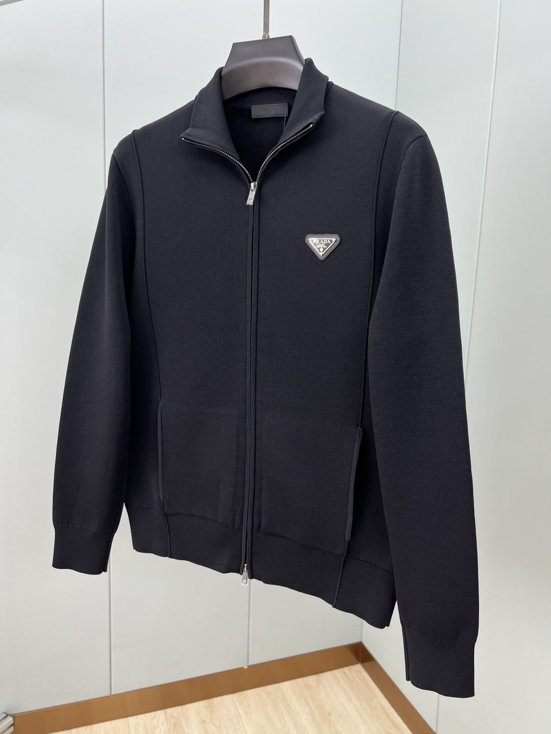 Prada.普拉达 25秋冬经典涂珐琅三角金属徽标立领棉质混纺针织开衫，正面胸前饰有经典标志性特色金属三