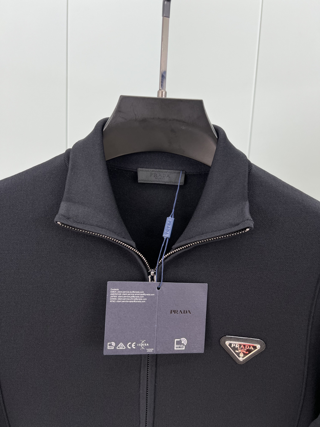 Prada.普拉达 25秋冬经典涂珐琅三角金属徽标立领棉质混纺针织开衫，正面胸前饰有经典标志性特色金属三