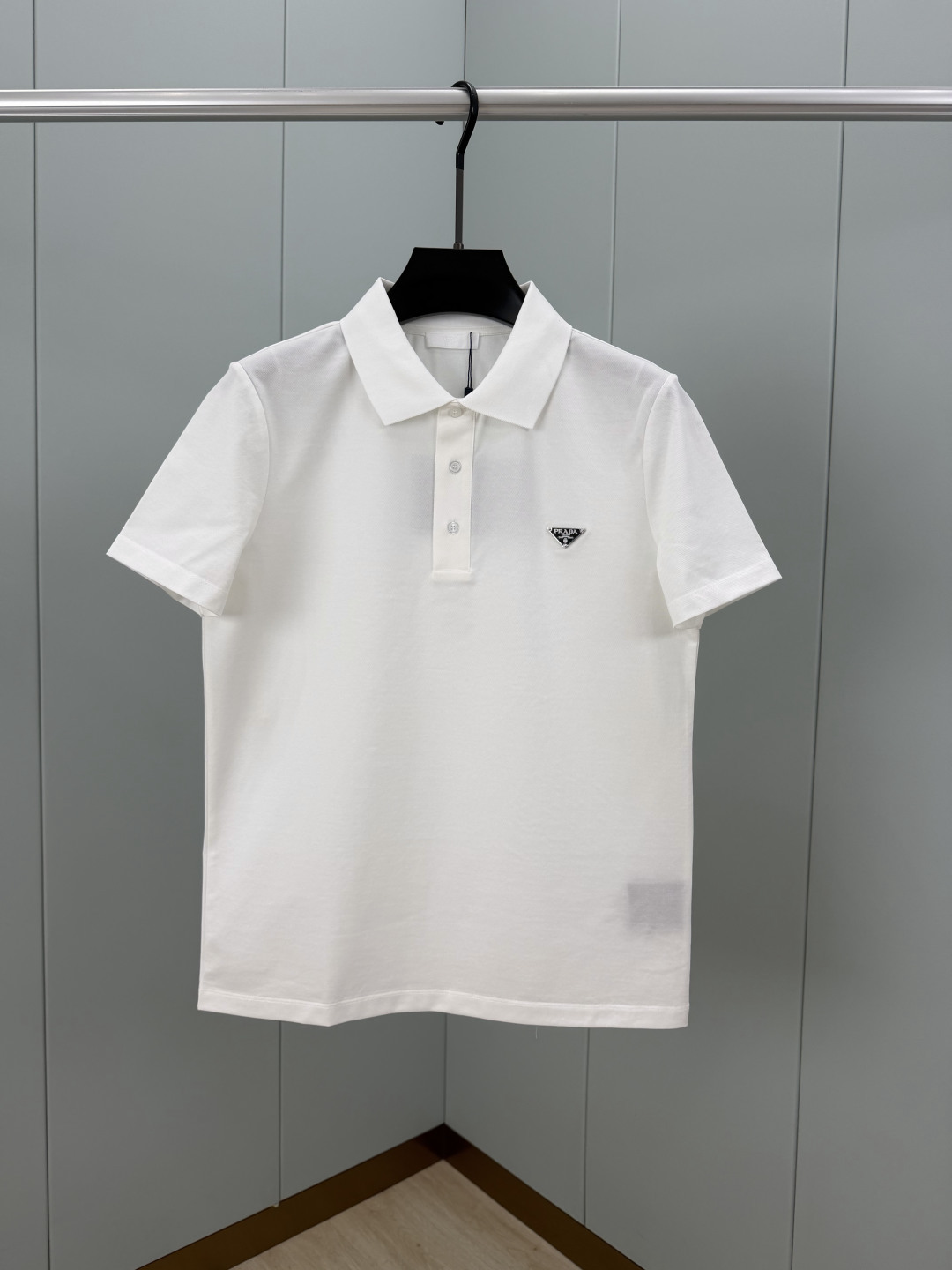 Prada.普拉达 SS26春夏新品经典标识涂珐琅金属三角形徽标Polo衫，以最简约的形式呈现，体现了休