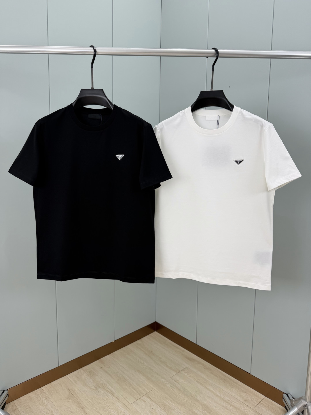 Prada.普拉达 SS26春夏新品经典标识涂珐琅金属三角形徽标短袖T恤，正面胸前饰有品牌经典标志性三角