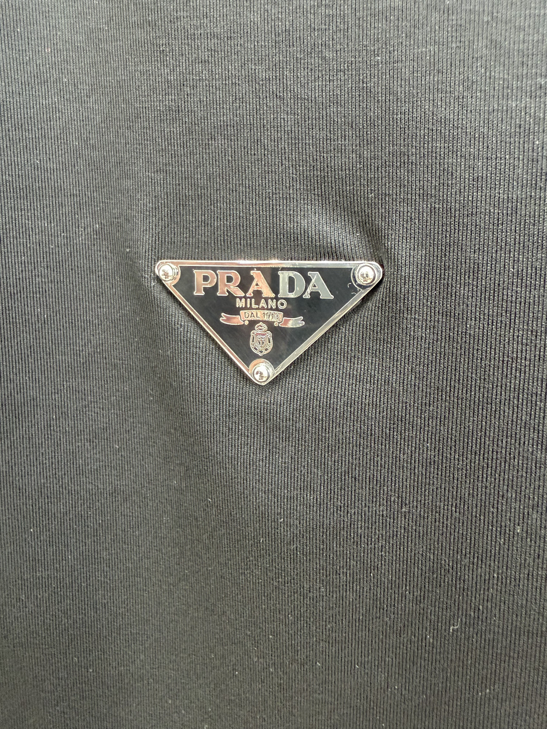 Prada.普拉达 SS26春夏新品经典标识涂珐琅金属三角形徽标短袖T恤，正面胸前饰有品牌经典标志性三角