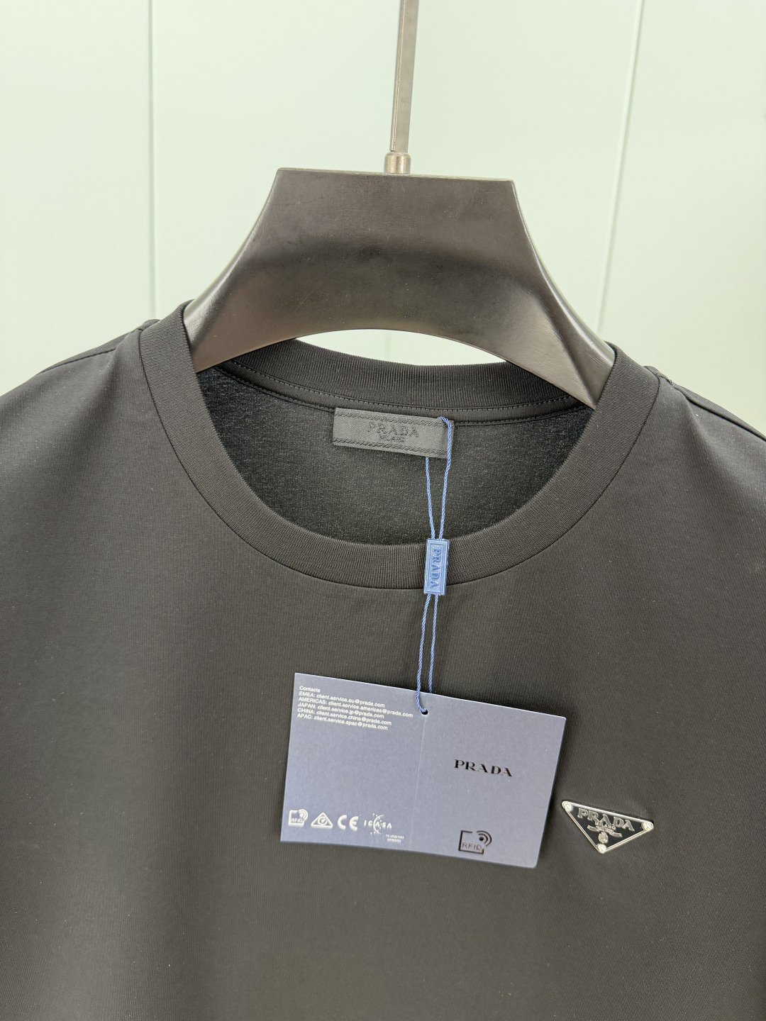 Prada.普拉达 SS26春夏新品经典标识涂珐琅金属三角形徽标短袖T恤，正面胸前饰有品牌经典标志性三角