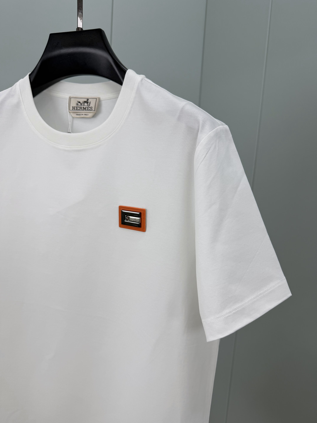 Hermès.爱马仕 SS26春夏新品品牌字母五金皮革徽章短袖T恤，正面胸前饰橙色皮革+品牌字母五金组合
