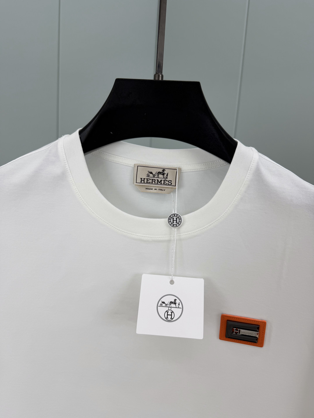 Hermès.爱马仕 SS26春夏新品品牌字母五金皮革徽章短袖T恤，正面胸前饰橙色皮革+品牌字母五金组合