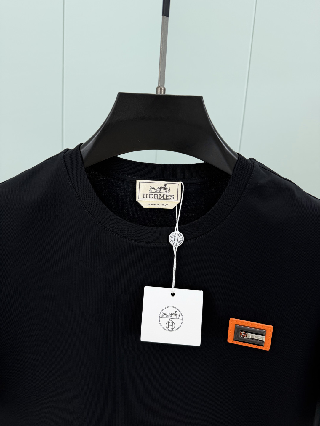 Hermès.爱马仕 SS26春夏新品品牌字母五金皮革徽章短袖T恤，正面胸前饰橙色皮革+品牌字母五金组合