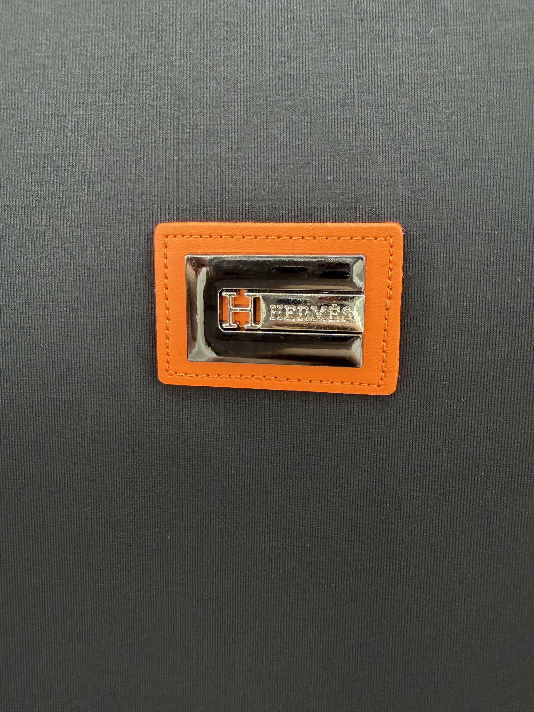 Hermès.爱马仕 SS26春夏新品品牌字母五金皮革徽章短袖T恤，正面胸前饰橙色皮革+品牌字母五金组合