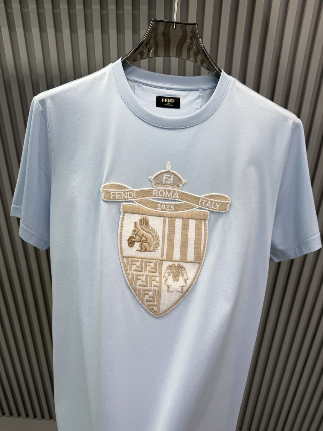 FENDI2026春夏系列的盾形徽章刺绣短袖T恤，设计风格兼具品牌经典元素与现代潮流感，适合日常穿搭或轻