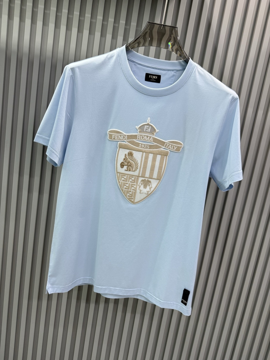 FENDI2026春夏系列的盾形徽章刺绣短袖T恤，设计风格兼具品牌经典元素与现代潮流感，适合日常穿搭或轻