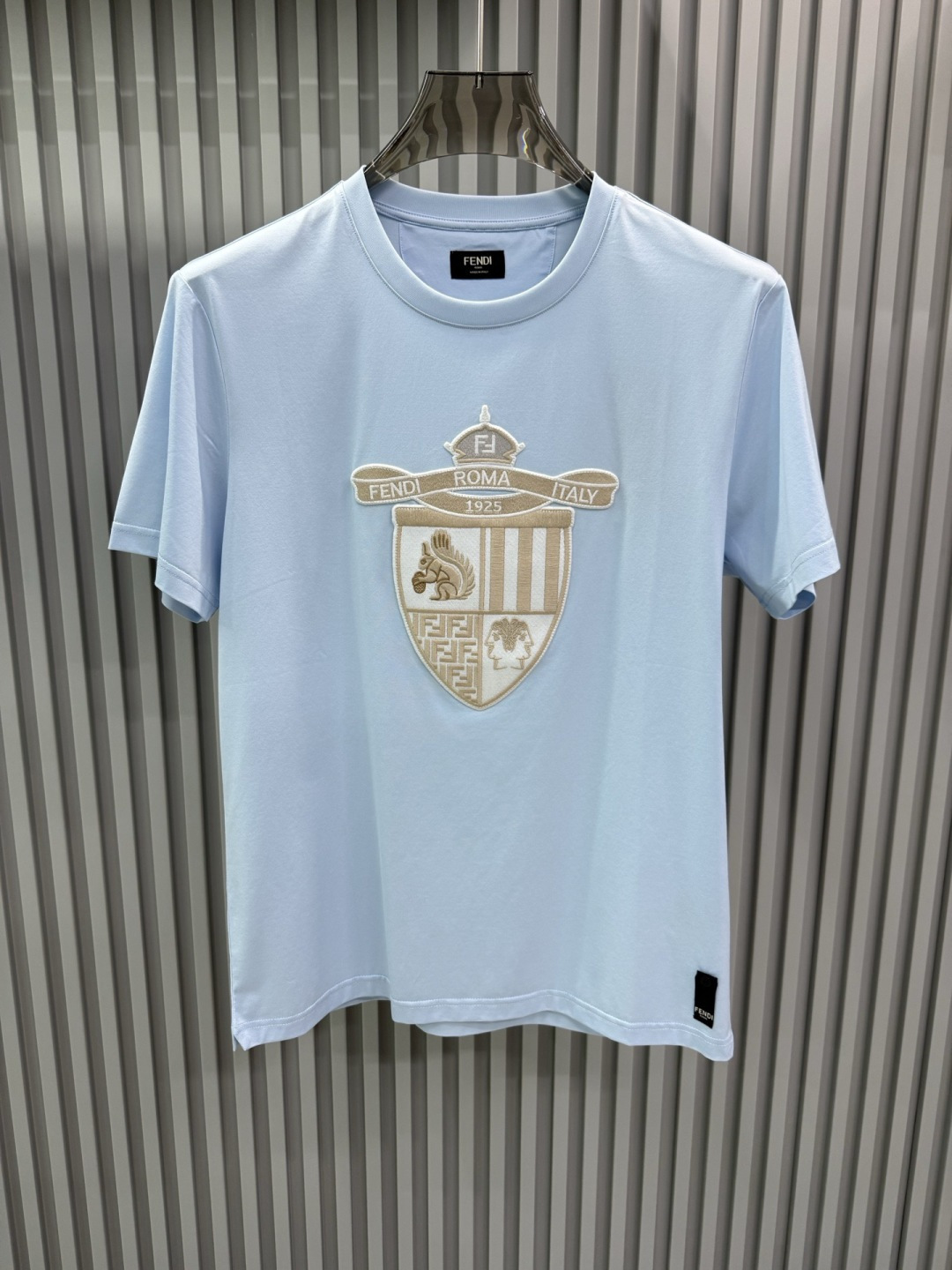 FENDI2026春夏系列的盾形徽章刺绣短袖T恤，设计风格兼具品牌经典元素与现代潮流感，适合日常穿搭或轻