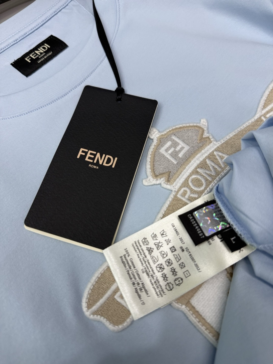 FENDI2026春夏系列的盾形徽章刺绣短袖T恤，设计风格兼具品牌经典元素与现代潮流感，适合日常穿搭或轻