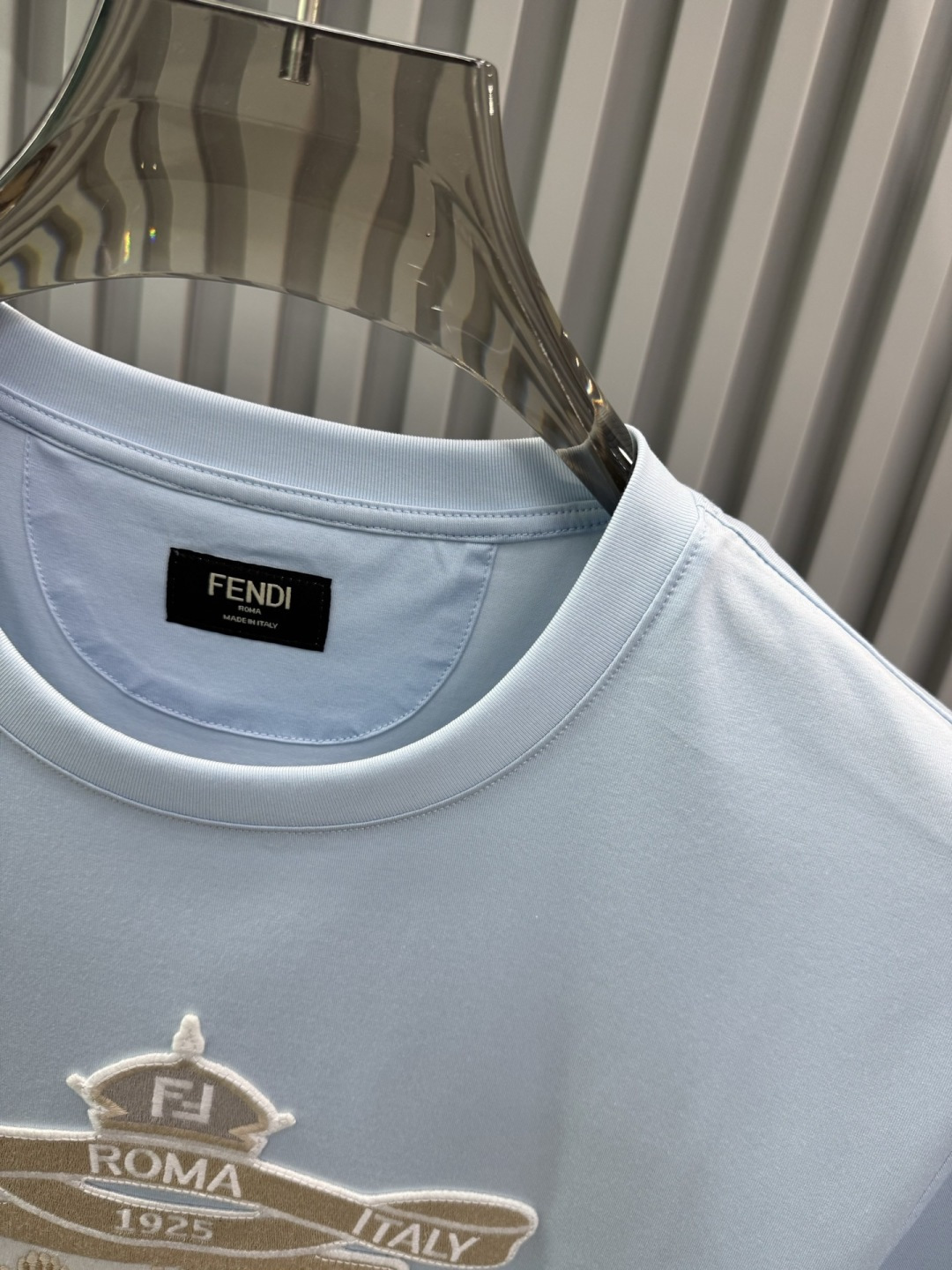 FENDI2026春夏系列的盾形徽章刺绣短袖T恤，设计风格兼具品牌经典元素与现代潮流感，适合日常穿搭或轻