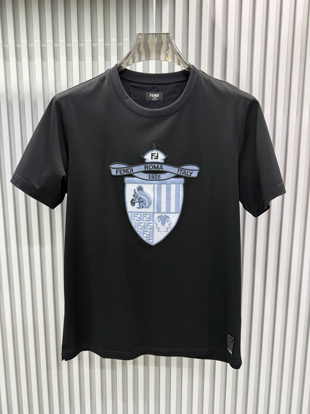 FENDI2026春夏系列的盾形徽章刺绣短袖T恤，设计风格兼具品牌经典元素与现代潮流感，适合日常穿搭或轻