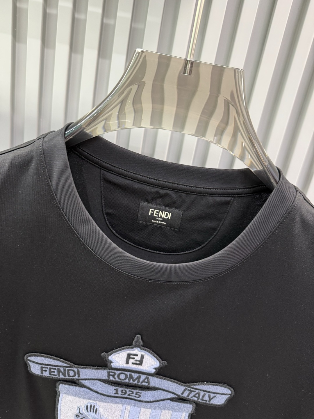 FENDI2026春夏系列的盾形徽章刺绣短袖T恤，设计风格兼具品牌经典元素与现代潮流感，适合日常穿搭或轻