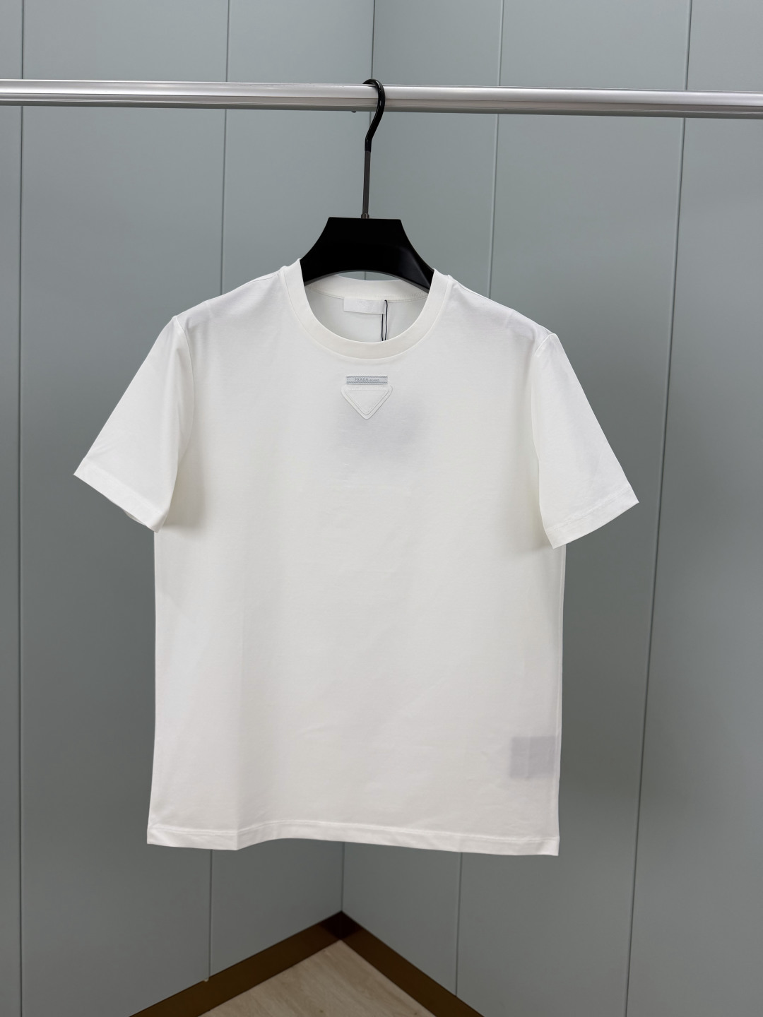 Prada.普拉达 SS26春夏新品三角形贴布徽标&缝制标签短袖T恤，正面领口装饰标志性的三角形徽标几何