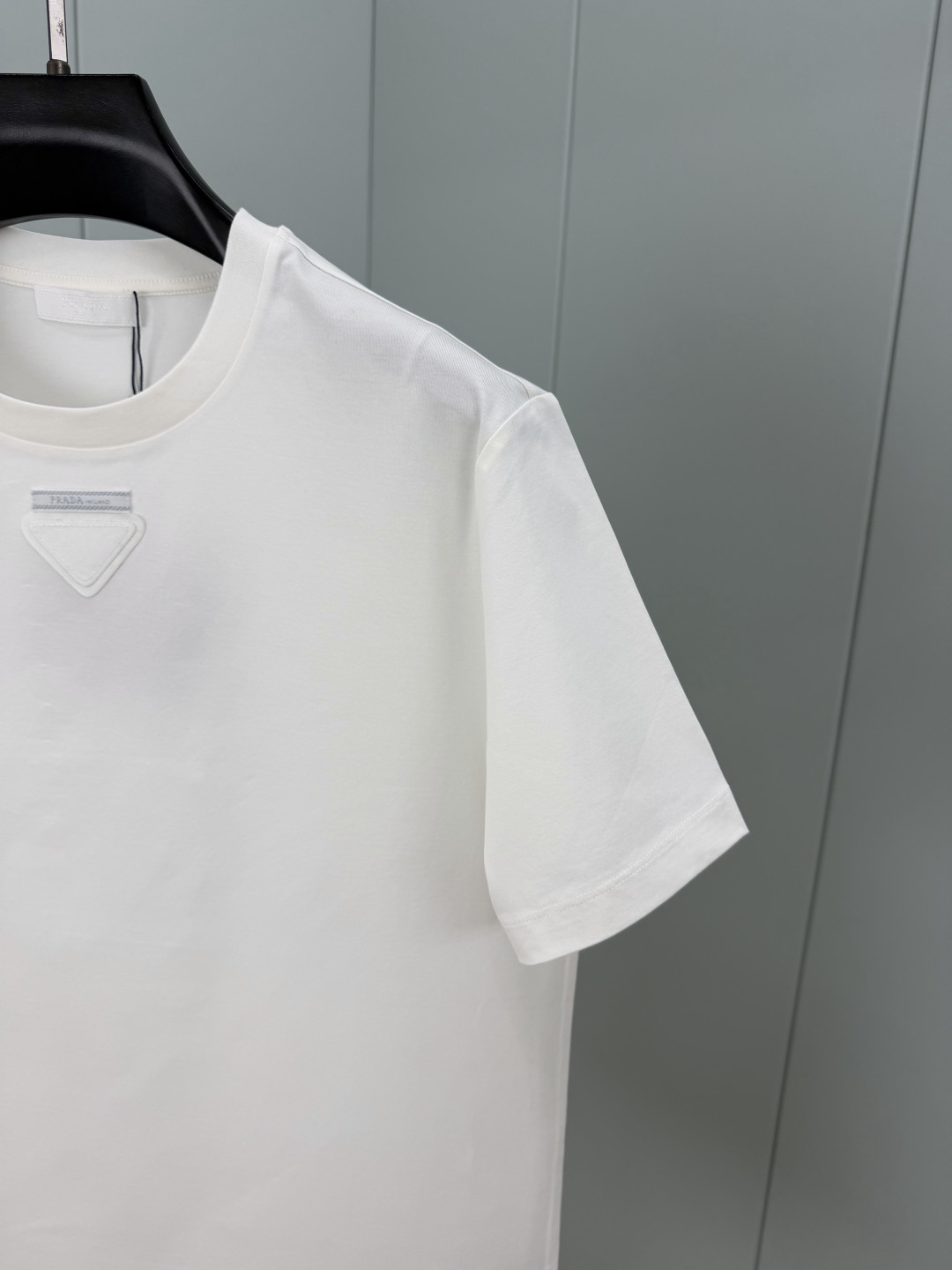 Prada.普拉达 SS26春夏新品三角形贴布徽标&缝制标签短袖T恤，正面领口装饰标志性的三角形徽标几何