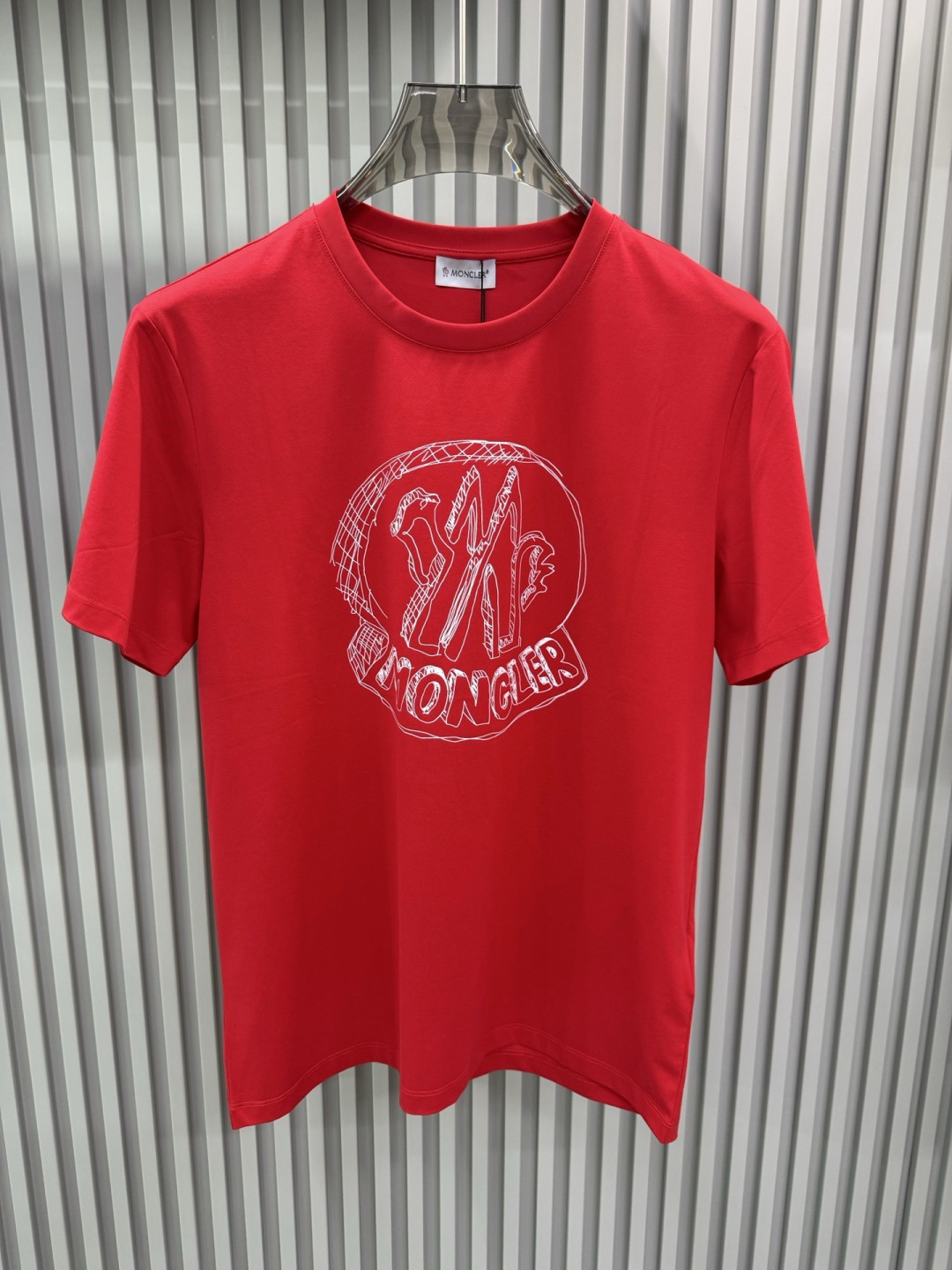 Moncler2026春夏新品抽象印花圆领短袖T恤，主打简约时髦与品牌辨识度的结合。正面采用白色手绘风格