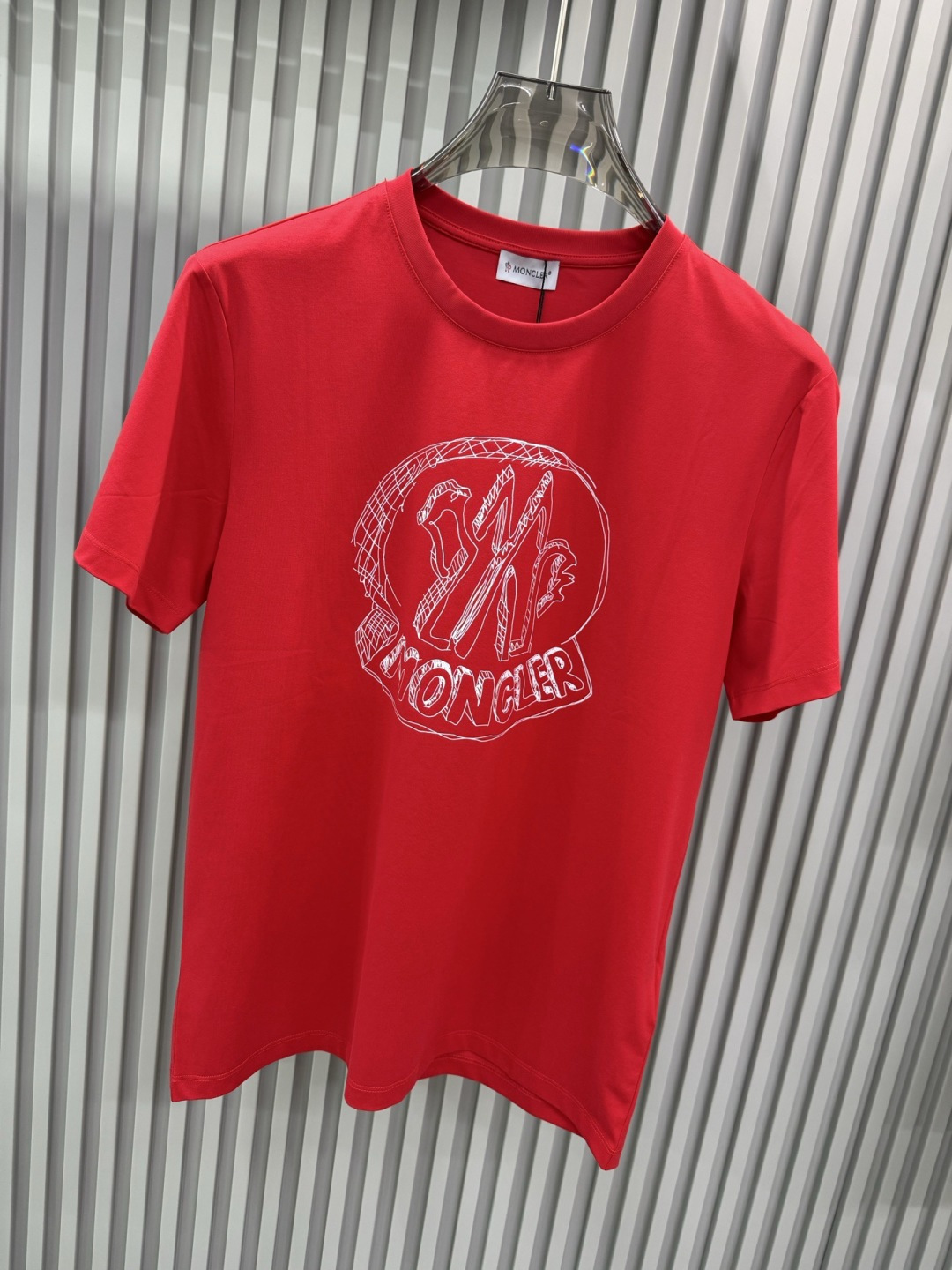 Moncler2026春夏新品抽象印花圆领短袖T恤，主打简约时髦与品牌辨识度的结合。正面采用白色手绘风格