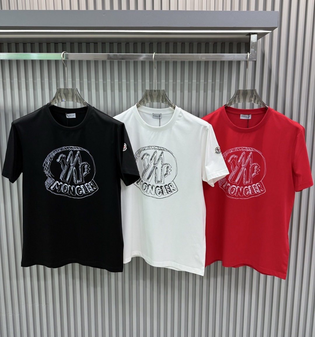 Moncler2026春夏新品抽象印花圆领短袖T恤，主打简约时髦与品牌辨识度的结合。正面采用白色手绘风格
